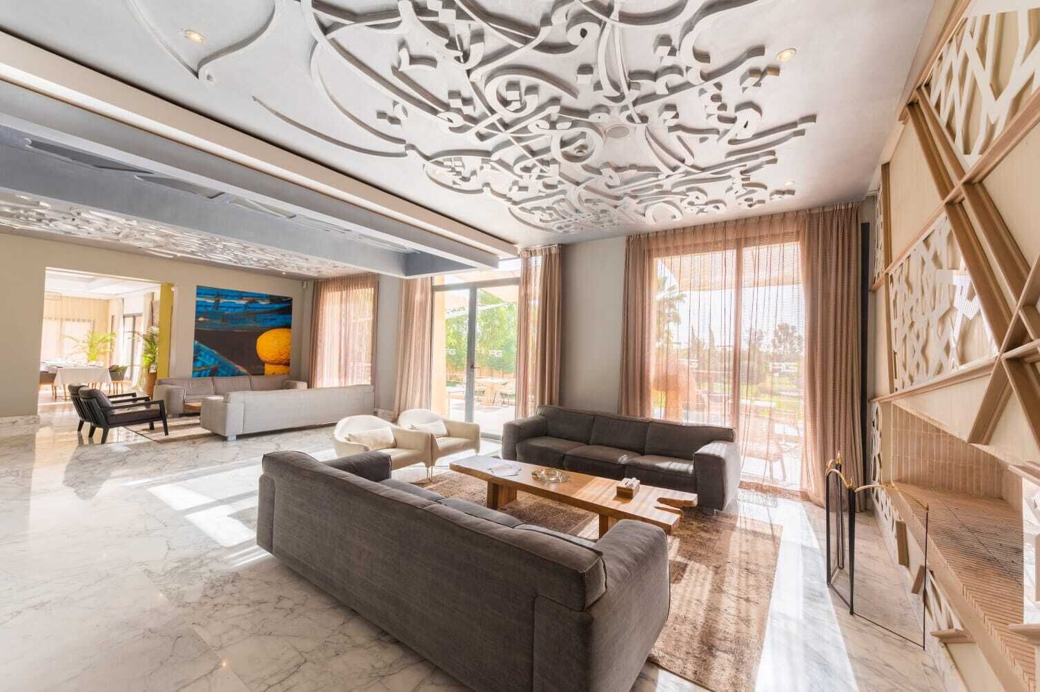 Een ruime woonkamer met een grote bank, een salontafel en een eethoek met een tafel en stoelen.