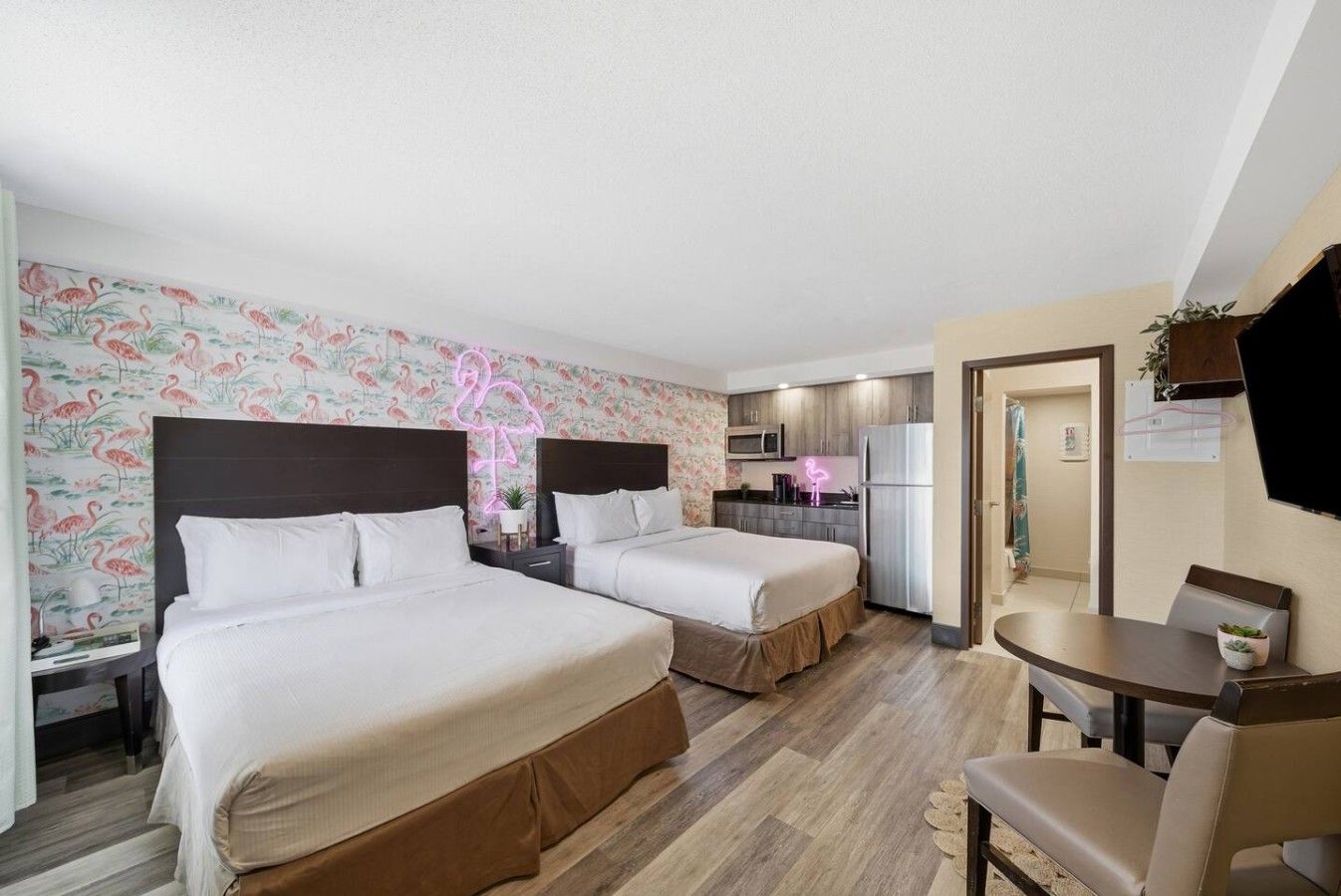 Une chambre d’hôtel avec deux lits, une kitchenette, un coin repas et une salle de bain.