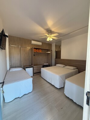 A hotel room with two single beds, a wardrobe, a desk, a chair, and a ceiling fan. - HOTEL FAZENDA SERTÃO VEREDA SETE LAGOAS  (Paraopeba)