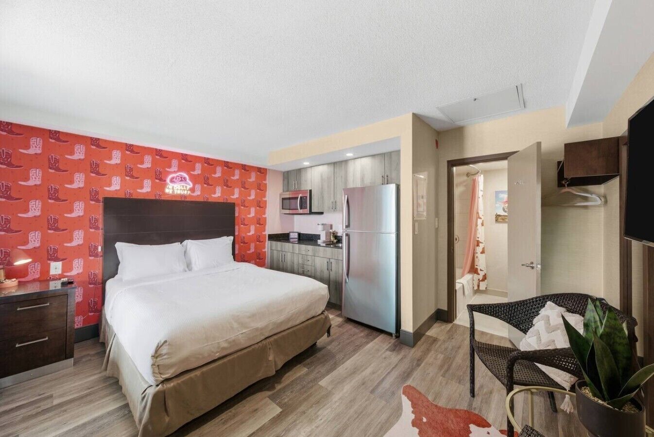 Une chambre d’hôtel comprenant un lit, une kitchenette, une salle de bain et un coin salon.