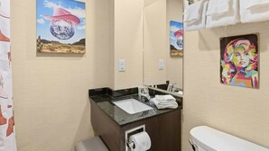 Een badkamer met een wastafel, spiegel en handdoekrek.