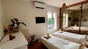 Un dormitorio con dos camas, un radiador, una ventana y un espejo.