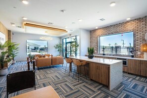 Una cocina moderna con una isla grande, taburetes de bar y vistas por una ventana.