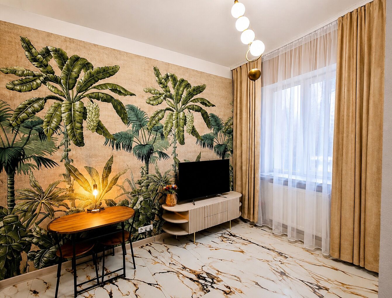 Un soggiorno con televisione a schermo piatto, un tavolo da pranzo e un affresco con motivi tropicali.