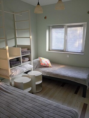 A small, cozy bedroom with a bunk bed, a bedside table, a lamp, and a window with blinds. - Stunning 100m² Modern Townhouse with Sea Views & Private Garden (Ližnjan)