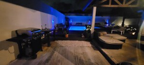 Ein Zimmer mit Pool, Grill und einer Couch.