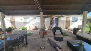 An outdoor patio area with a covered seating arrangement, including a table and chairs, and a wicker sofa. - URBAN OASIS GARDEN ARUBA
Lovely studio with AC in Oranjestad (Oranjestad)