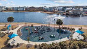 A waterfront park with playground equipment and a fountain. - Coco Beach - Walk to Carolina Beach, Family Friendly Townhome (Carolina Beach)