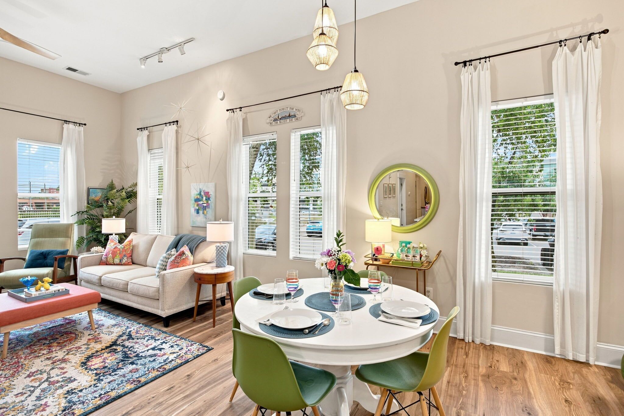 A modern living room with a sofa, coffee table, and dining area with a round table set for four.