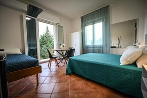 Une chambre d’hôtel équipée d’un lit, d’un bureau, d’une chaise et offrant une vue sur l’extérieur.