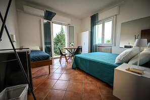 Une chambre à coucher avec un lit, un bureau, une chaise et une fenêtre.