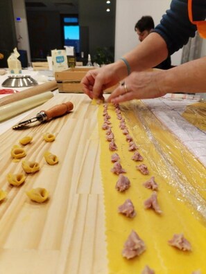 A person preparing ravioli on a table with pasta sheets and filling. - B&B La Tana de Lupo - Quadruple Room with Private Bathroom: Comfort & Nature   (Savigno)