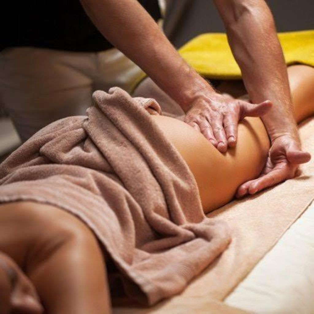 A person receiving a massage on a massage table.