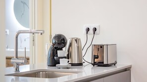 Eine moderne Küche mit Kaffeemaschine, Wasserkocher und Toaster auf der Arbeitsfläche.