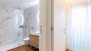 Ein modernes Badezimmer mit einer Duschkabine, einem Holzwaschtisch und einer weißen Toilette.