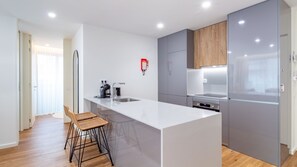 Eine moderne Küche mit Kochinsel, Edelstahlgeräten und einem Holzkorpus.