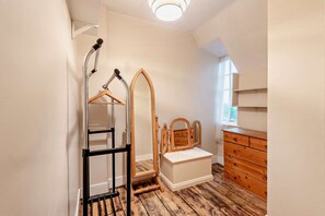 A room with a wooden dresser, a mirror, and a hanging rack. - Host & Stay | Lavender Cottage SLEA (Pointon)