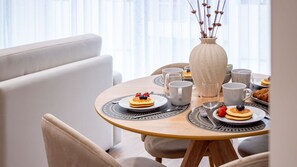A dining area with a round table set for breakfast, including pancakes, berries, and pastries. - Polacos Residence | 1BR | Apt M by LovelyStay (Vila Nova de Gaia)