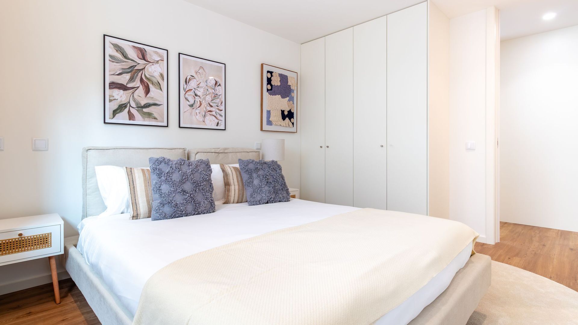 A bedroom with a bed, pillows, a nightstand, and a wardrobe.