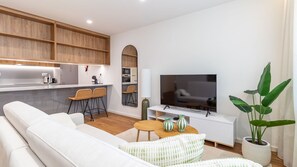 A modern living room with a sofa, TV, and a dining area with chairs. - Polacos Residence | 1BR | Apt V by LovelyStay (Vila Nova de Gaia)