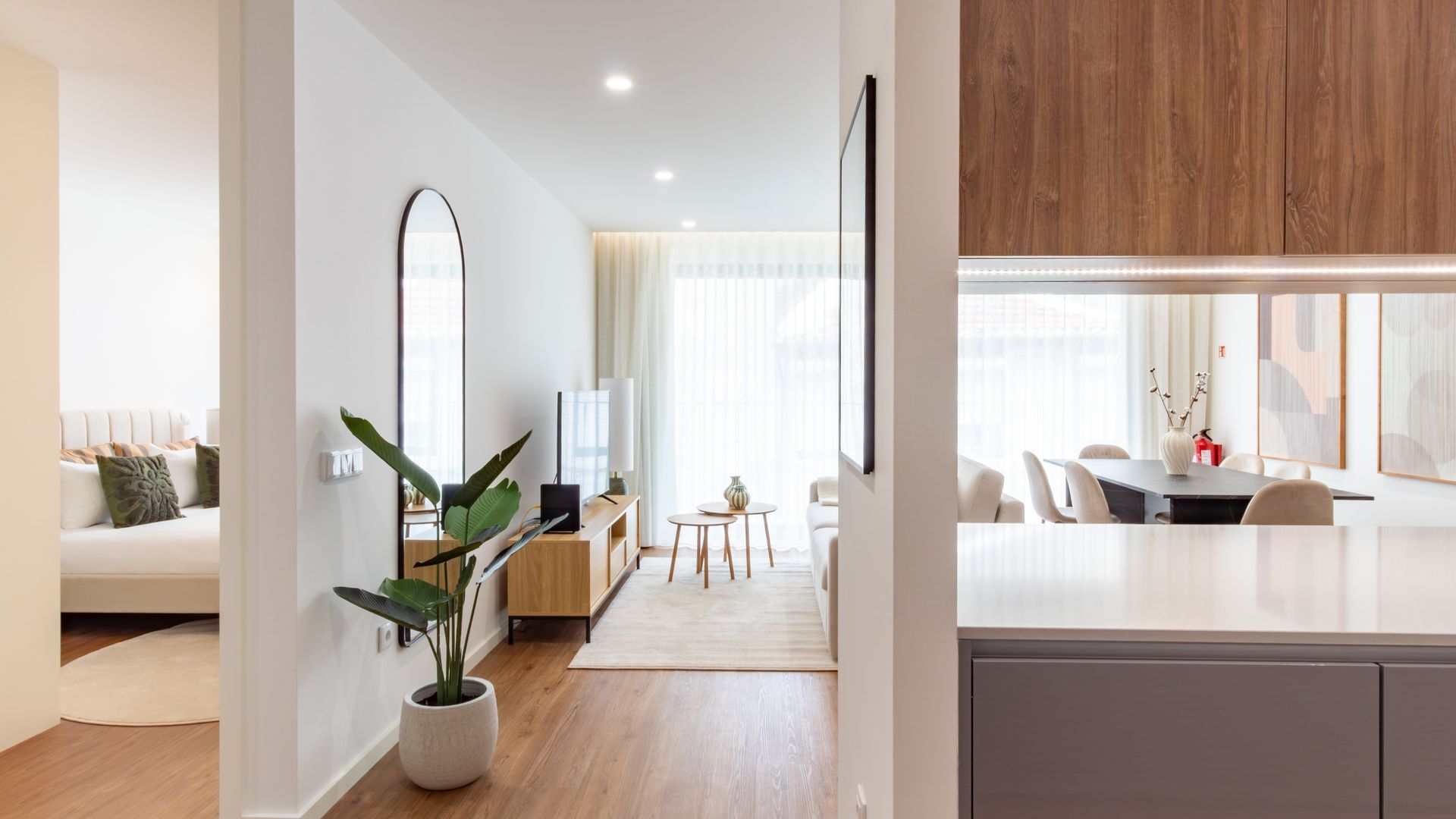 A modern living room with a sofa, a coffee table, and a large mirror.