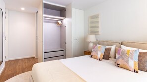 Ein Schlafzimmer mit einem Bett, einem Nachttisch, einem Schrank und einer Tür.