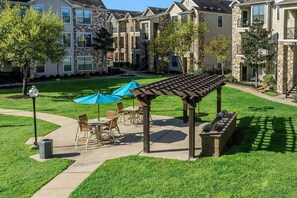 A courtyard with outdoor seating, a pergola, and stone buildings in the background. - Landing Chic 1bd, Clubhouse, Gym (Katy)