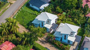 Zona residencial con casas, una calle y abundante vegetación.