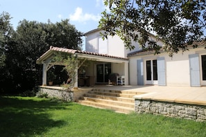 A house with a covered porch, stone steps, and a garden.