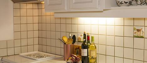 A kitchen with white cabinets, a tiled backsplash, a stove, and a sink.