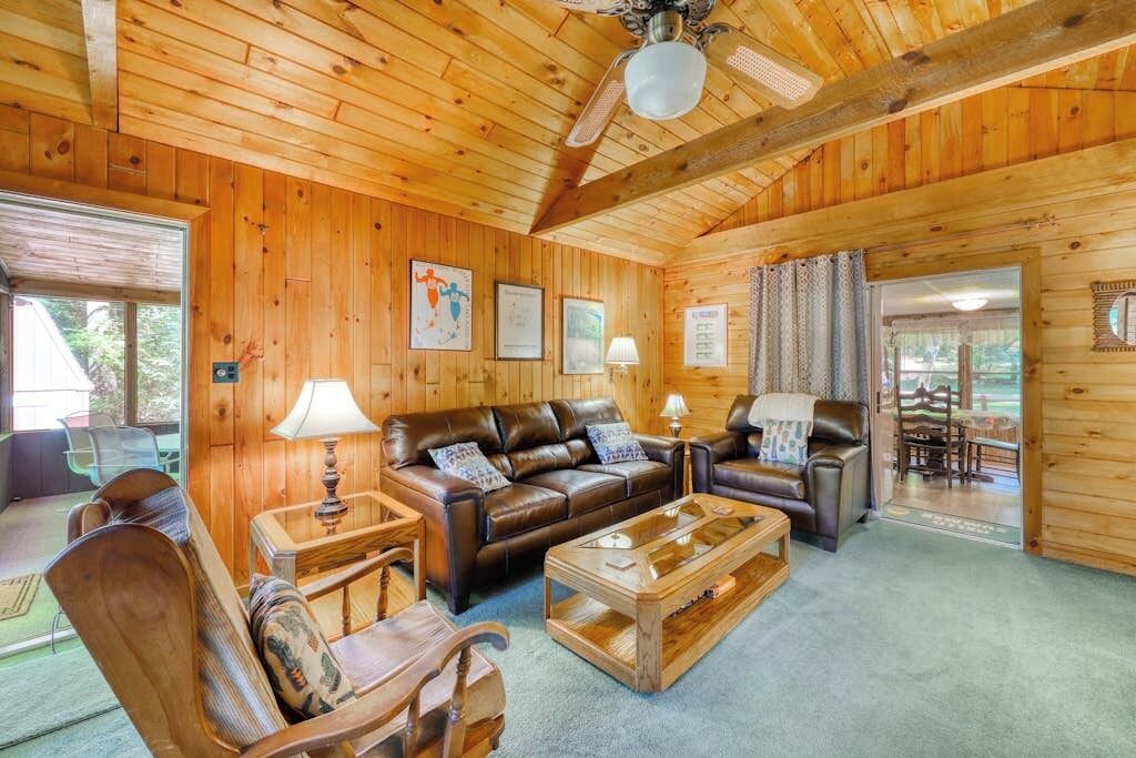 Un interno in legno con un divano, poltrone, un tavolino da caffè e una ventola a soffitto.