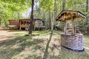 A cabin with a wooden exterior, surrounded by a forested area.