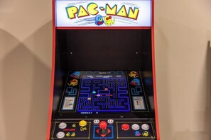 A Pac-Man arcade machine with a maze game, score display, and control buttons. - New 5-BR Home with Movie Theater, Bar, Game Room (Lake George)
