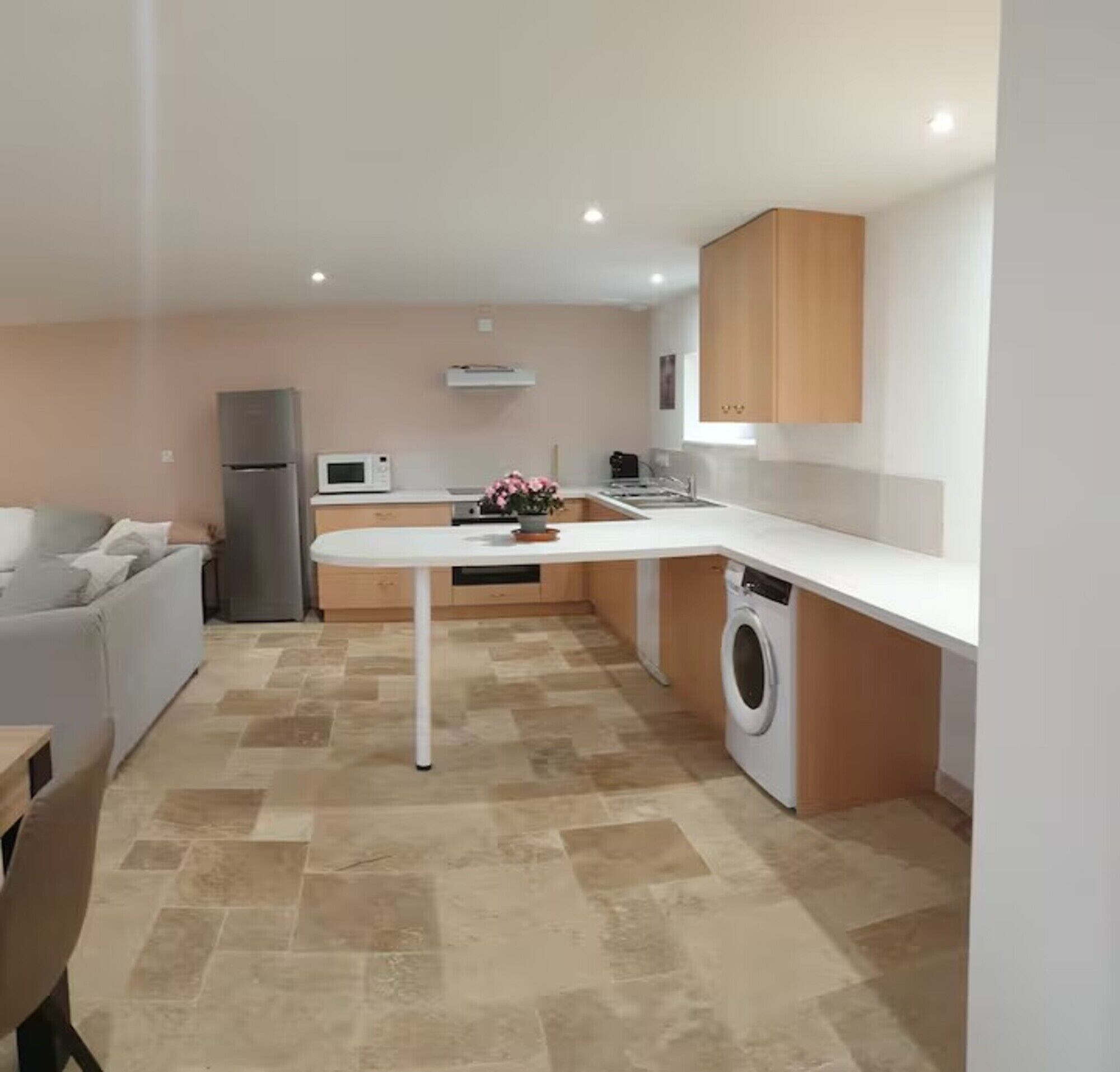 A compact kitchen with a washing machine, a microwave, and a refrigerator.