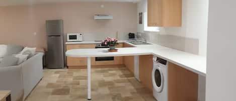 Cocina compacta con lavadora, microondas y refrigerador.