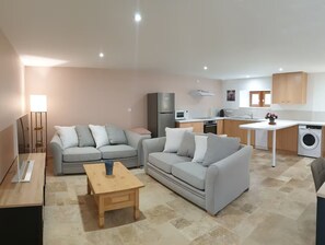 A modern apartment with a living room, kitchenette, and a dining area. - Holiday Home 'Barn Cottage' with Wi-Fi (Bourniquel)