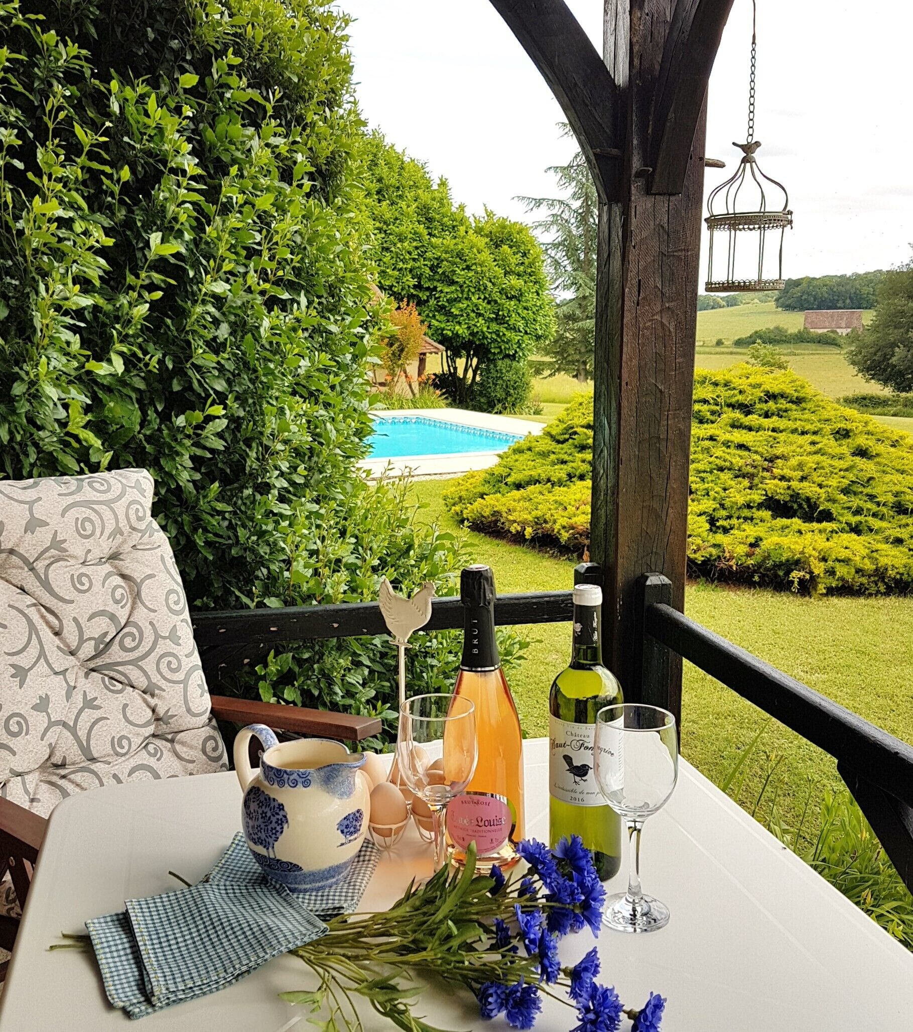 Ein Tisch im Freien mit Blick auf einen Swimmingpool, umgeben von üppiger Vegetation.