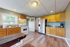 A kitchen with wooden cabinets, a stainless steel refrigerator, a stove, and a window. - Walk to Canandaigua Spots, Wine Trail, Lakes (Canandaigua)