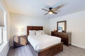 A bedroom with a bed, a nightstand, a dresser, a ceiling fan, and a window. - 3BR house, dog-friendly, beach access, bbq, withd (Schroon Lake)