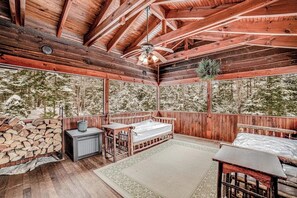 A cabin with a wooden interior, a bed, a table, and a fireplace. - Luxe 4BR Mountainview Adirondacks (North Creek)