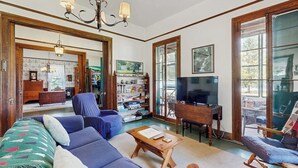 A living room with a sofa, coffee table, TV, and bookshelf. - Gorgeous, dog-friendly 6BR with amazing views (Rock Stream)