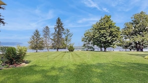 Un área verde bien cuidada con árboles y vista al agua.