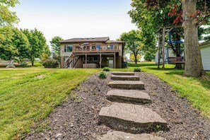A two-story house with a front porch and a staircase leading to the entrance. - Keuka Vista|Lakefront 4BR with amazing views, dock & game room (Penn Yan)