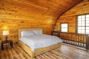A wooden cabin bedroom with a bed, a nightstand, and a window. - Spacious Studio Lakeview Finger Lakes - Balcony (Burdett)