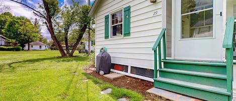 Une maison avec un porche verdoyant à l’avant, le numéro « 29 » sur la porte et une pelouse avec un arbre.