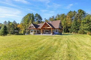 Une grande maison avec une vaste pelouse et un jardin bien entretenu.