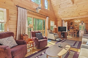 A cozy cabin interior with a fireplace, wooden walls, a television, and a dining area. - Beautiful 5BR Lakefront Adirondacks - Dock (Chestertown)