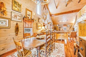 A wooden interior with a dining area, kitchen, and a large window. - Dog-friendly 2BR cabin with mountain view (Indian Lake)