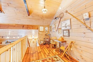 A wooden interior with a staircase, a dining area, and a wall adorned with framed pictures. - Dog-friendly 2BR cabin with mountain view (Indian Lake)
