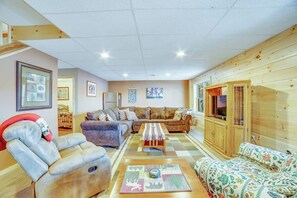 Un salon chaleureux avec un canapé, un fauteuil et un meuble en bois.